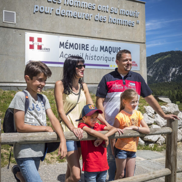 Visite en famille au Plateau des Glieres devant le batiment d'accueil 'memoire du maquis'.